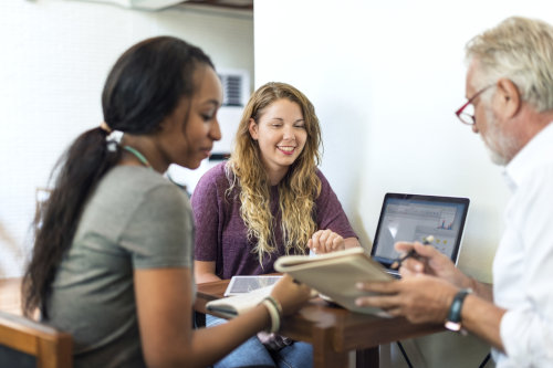 Business school students consulting with a lecturer